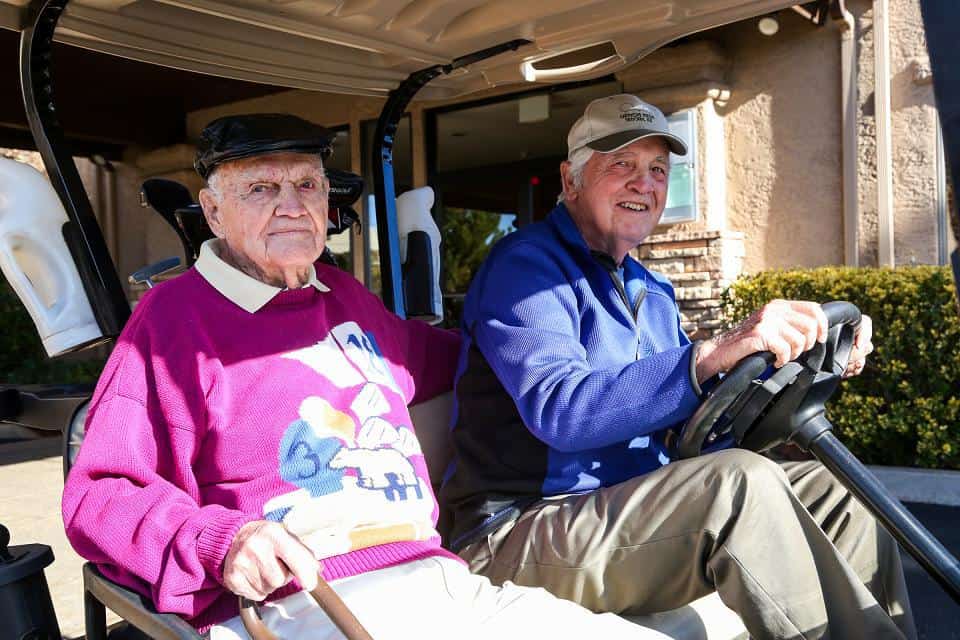 Claunts, left, and his golfing buddy Arland "Rev" Averill in a golf cart at Canyon Mesa Country Club. Claunts' golfing buddies must tee his ball for him at every hole, and direct him where to aim. 